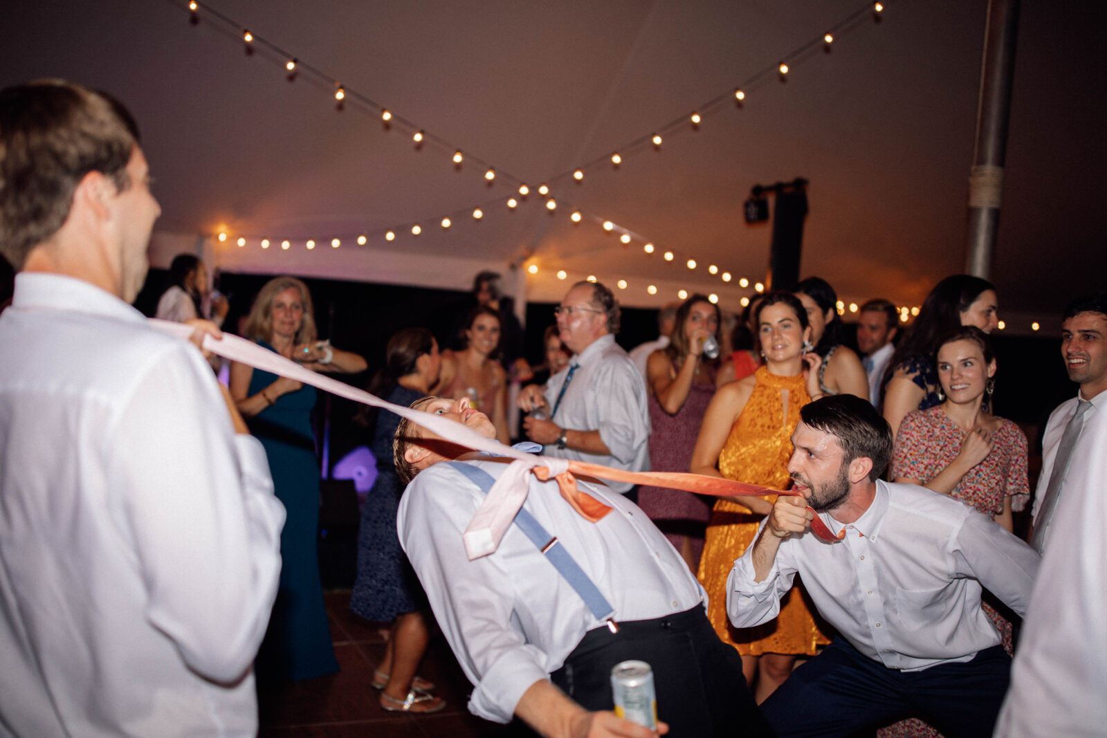 Fun dancing wedding reception photos with direct flash and colorful editing. Funny wedding reception dancing photos. Tie limbo
